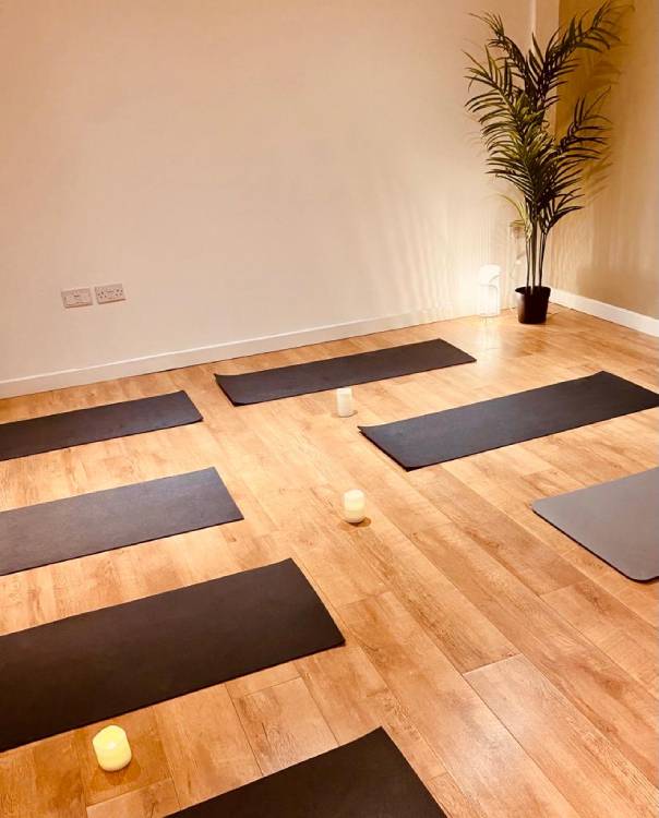 Yoga mats on an exercise studio wooden floor with ambient lighting and candles
